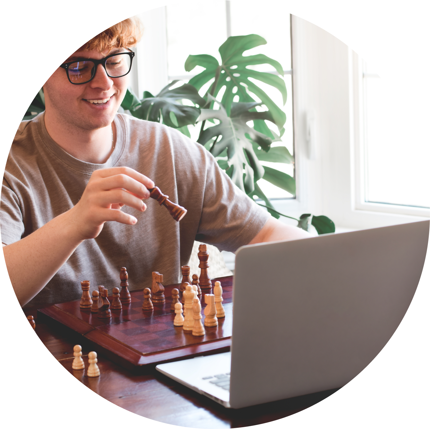 Person playing chess in front of a laptop
