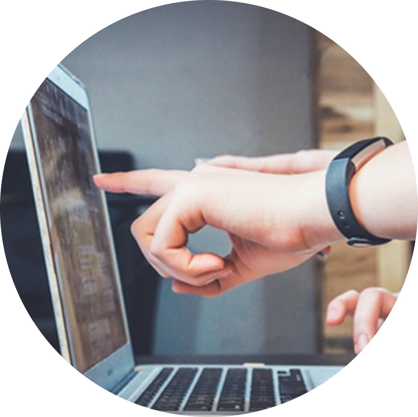 Hand pointing at laptop screen