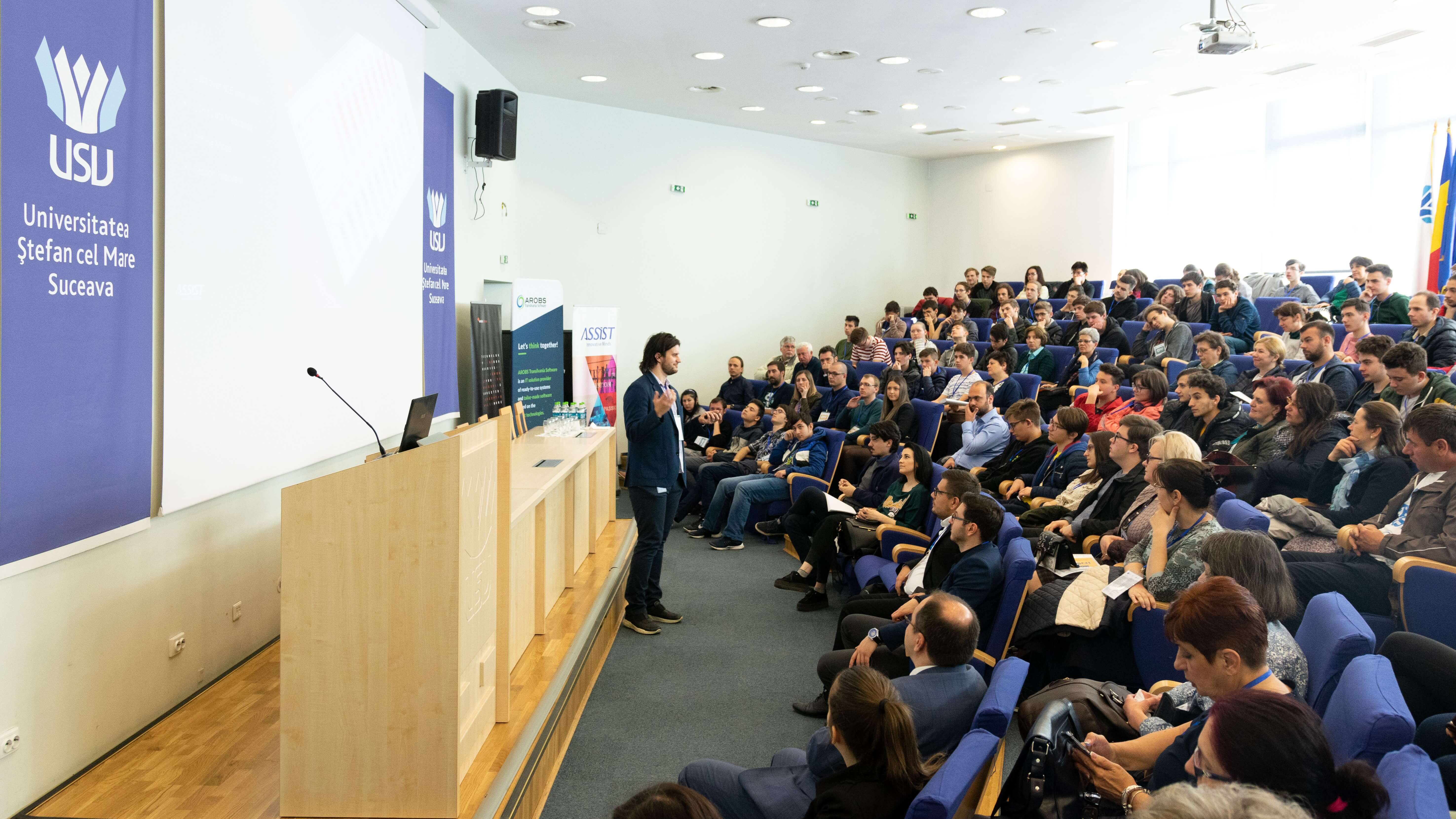 ASSIST Software representative Alexandru Boca, talking in front of high school students